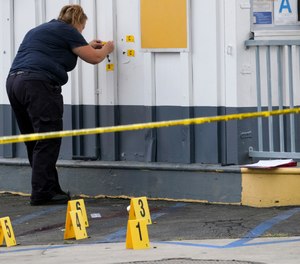 LAPD crime investigators collect evidence at one of the scenes of a shooting, a Shell gas station in the North Hollywood section of Los Angeles on Thursday, July 25, 2019.