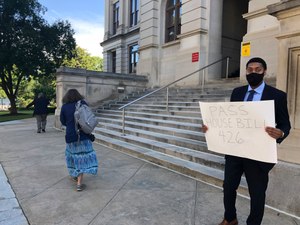 Lawyer Daniel Brown holds a poster calling on Georgia lawmakers to pass a state hate crimes law on Thursday, June 18, 2020 in Atlanta. Image: AP Photo/Jeff Amy