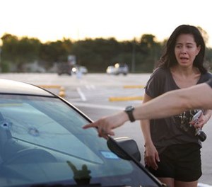 Alan Wakim shows his wife, Jennifer Molleda, where two bullets entered his windshield and went past his face during a shooting along Wesleyan at Law Street in Houston that left multiple people injured and the alleged shooter dead, Sunday morning, Sept. 25, 2016, in Houston. (Mark Mulligan/Houston Chronicle via AP)