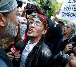 A professed supporter of President Donald Trump, center, argues with a counterprotester, left, at a