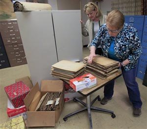 In this Oct. 30, 2014 photo, Teresa Corall, director of Records Retention for Summit County, left, and Karen Kearns, look over records from the 1920s and 30s found in the attic of the Summit County Courthouse in Cuyahoga Falls, Ohio.