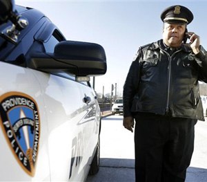 In this Tuesday, Jan. 13, 2015 photo, Rhode Island state Rep. Raymond Hull, D-Providence, also a Providence police sergeant, speaks on a mobile phone near his cruiser, in Providence, R.I.
