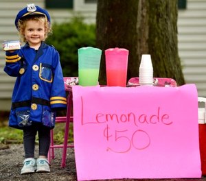 In this Sunday, June 4, 2017 photo, Hannah Pasley, an aspiring cop, poses for a photo at her lemonade stand in Kansas City, Mo.