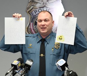 Anne Arundel County Police Chief Timothy Altomare holds up letters written to Detective William Ballard and Detective Ian Preece, who were shot last week by a fleeing suspect. (Photo/TNS)