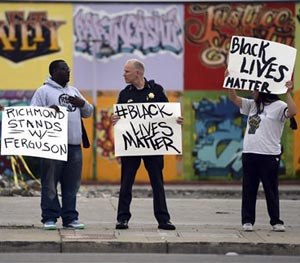 In this photo Richmond Chief of Police Chris Magnus chats with Randy Joseph, second from left, of Berkeley, as they stand with William McCoy, left, of Sacramento, and with the RYSE Youth Center trauma response service.