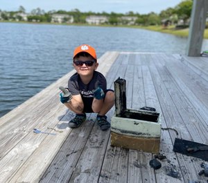 Knox Brewer poses next to a safe he pulled out of Whitney Lake in South Carolina. (Photo/AP)