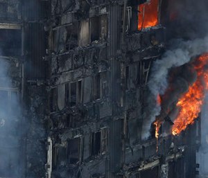 Smoke and flames billow from a massive fire that raged in a high-rise apartment building in London. (AP Photo/Matt Dunham)