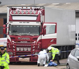 Police and forensic officers at the Waterglade Industrial Park in Grays, Essex, England after 39 bodies were found inside a truck on the industrial estate.