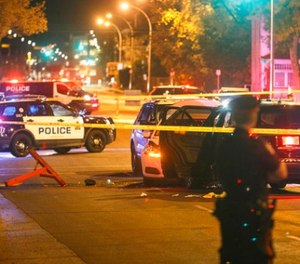 Police investigate the scene where a car crashed into a roadblock in Edmonton Alta, on Saturday, Sept. 30, 2017. (Jason Franson/The Canadian Press via AP)