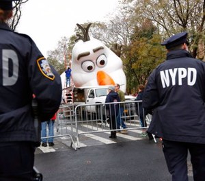 Police officers stand near the site where a large balloon of Olaf, from the animated film, "Frozen", is being inflated for the Thanksgiving Day parade in New York, Wednesday, Nov. 22, 2017. (AP Photo/Seth Wenig)