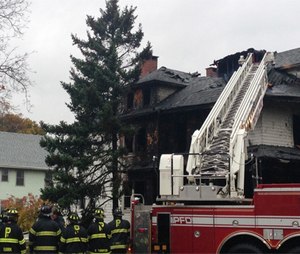Firefighters work the scene after a fatal fire swept through a two-apartment building housing students from the University of Southern Maine.