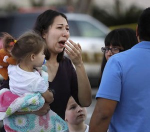 A woman holds her child after San Antonio police helped her and other shoppers exit the Rolling Oaks Mall, Sunday, Jan. 22, 2017, in San Antonio, after a deadly shooting. (AP Photo/Eric Gay)