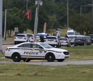 Tulsa police gather where two officers were shot near 21st Street and Memorial Drive in Tulsa, Okla., on Monday, June 29, 2020.