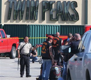 Authorities investigate a shooting in the parking lot of the Twin Peaks restaurant Sunday, May 17, 2015, in Waco, Texas.