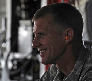 General Stanley McChrystal wears earplugs as he leaves by helicopter after a meeting between President Hamid Karzai and tribal leaders in Kandahar city, Afghanistan, Sunday June 13, 2010.