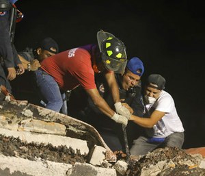 Rescue workers and volunteers search a building that collapsed after an earthquake, in the Colonia Obrera neighborhood of Mexico City.