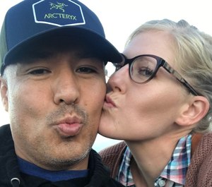 Officer Valentin Martinez and his longtime partner Megan Flynn share a kiss. (Photo/Megan Flynn via GoFundMe)