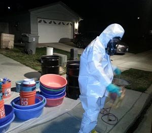 In this March 2014 photo provided by PARC Environmental, Jeff Davis, a hazardous materials specialist for PARC Environmental, cleans up a meth conversion lab inside a house in Madera, Calif.
