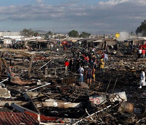 Firefighters and rescue workers walk through the scorched ground of Mexico's best-known fireworks market after an explosion explosion ripped through it, in Tultepec, Mexico, Tuesday, Dec. 20, 2016. (AP Photo/Eduardo Verdugo)
