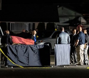 Investigators move the body of a man who is reportedly Michael Forest Reinoehl after he was shot and killed by law enforcement on September 3, 2020 in Lacey, Washington. (Nathan Howard/Getty Images/TNS)