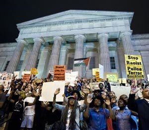 Demonstrators chant at the steps of the National Portrait Gallery in Washington, Saturday, Aug. 23, 2014, during a protest against the shooting of unarmed Michael Brown, a black 18-year-old killed by a white police officer in Ferguson, Mo. (AP Image)