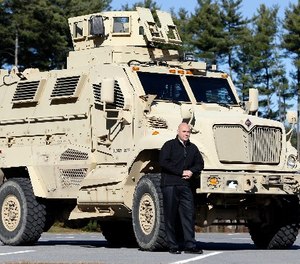 In this Wednesday, Nov. 13, 2013 photo, Warren County Undersheriff Shawn Lamouree poses in front the department's mine resistant ambush protected vehicle, or MRAP, in Queensbury, N.Y.