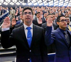 New York Police Department (NYPD) recruits raise their right hands in a pledge during a swearing-in ceremony for new recruits at the Police Academy, Thursday, July 6, 2017, in New York.