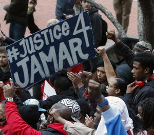 In this March 30, 2016 photo, demonstrators raise their fists in the air at the Government Center in Minneapolis during a protest over two Minneapolis police officers fatally shooting Jamar Clark, a black man, in November 2015.