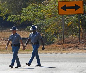 Mississippi Highway Patrol troopers walk along U.S. Highway 80 in Chunky, Miss., Tuesday, Nov. 1, 2016, where authorities say on Monday night, a pickup truck slammed into a small utility trailer carrying a group of trick-or-treaters.