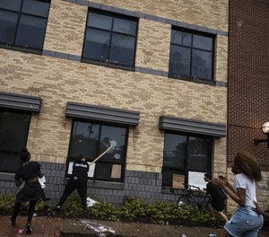 Protesters attempt to damage a police building in Minneapolis during demonstrations following the death of George Floyd.