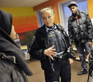 In a photo made Friday, Jan. 14, 2011, Minneapolis police officer Jeanine Brudenell talks with Somali young people in Minneapolis, Minn., who were on hand to sign up for a Minneapolis Police Department Citizens Academy geared toward keeping Somali kids out of gangs . (AP Photo/Jim Mone)