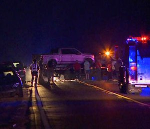 In this image made from video, people gather around a pickup truck on a flatbed truck at the scene of an accident on U.S. Highway 80 in Chunky, Miss., late Monday, Oct. 31, 2016.