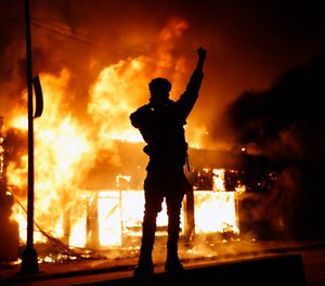 In this May 29, 2020, photo, a check-cashing business burns during protests in Minneapolis. Protests continued following the death of George Floyd, who died after being restrained by Minneapolis police officers on Memorial Day. (AP Photo/John Minchillo)