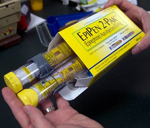 A pharmacist holds a package of EpiPens epinephrine auto-injector, a Mylan product. (AP Photo/Rich Pedroncelli)