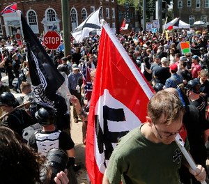 This Saturday, Aug. 12, 2017 image shows s white supremacist carrying a NAZI flag into the entrance to Emancipation Park in Charlottesville, Va.