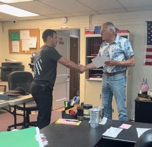 Sabin Ward, left, shakes hands with New Athens Mayor Joe Petro after being sworn-in.
