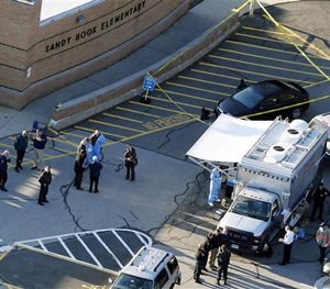 This Dec. 14, 2012 aerial file photo shows officials standing outside of Sandy Hook Elementary School in Newtown, Conn. (AP Image)
