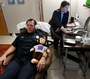 Brian McCoy, left, is one of about 50 first responders to try neurofeedback therapy, which re-trains the brain's response to negative stimuli associated with PTSD. (Photo/TNS)