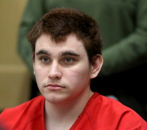 In this Aug. 15, 2018 file photo, Florida school shooting suspect Nikolas Cruz listens during a status check on his case at the Broward County Courthouse in Fort Lauderdale, Fla. Authorities say Cruz attacked a detention officer at the county jail, Tuesday, Nov. 13, and now faces new charges. Cruz is charged with killing 17 people and wounding 17 others in the Feb. 14 mass shooting at Marjory Stoneman Douglas High School.