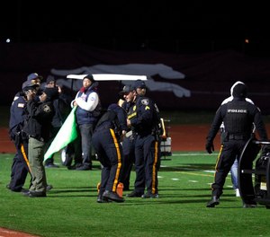 Police investigate the scene after a gunman shot into a crowd of people during a football game at Pleasantville High School in Pleasantville, N.J. (Photo/AP)