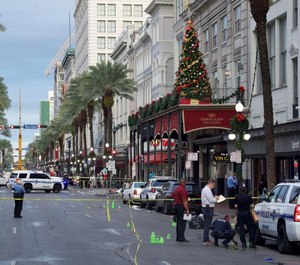 New Orleans police investigate the scene where 11 people were reported injured from gunshots early Sunday morning.