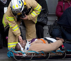 An injured passenger is assisted by an EMS worker as he lies on a gurney outside Atlantic Terminal after a Long Island Rail Road incident, Wednesday, Jan. 4, 2017, in the Brooklyn borough of New York. (AP Photo/Mark Lennihan)