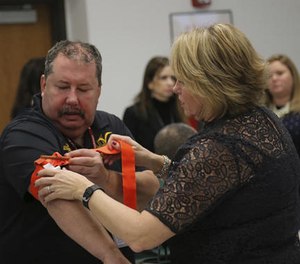 Two staffers from the Three Village Central School District in Stony Brook, N.Y., practice applying a tourniquet to one another during a first aid training session at Stony Brook University, Tuesday, Nov. 29, 2016, in New York.