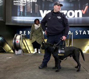 NYPD Counterterrorism Officer Frisna and his dog stand outside Penn Station in Manhattan. Under a proposed federal budget measure, the VIPR teams currently patroling many major transit hubs will be eliminated. (Photo/TNS)