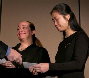 Maritza Ramos, left, and Pei Xia Chen, widows of slain New York City Police Officers Rafael Ramos and Wenjian Liu, receive checks from the Stephen Siller Tunnel to Towers Foundation, Wednesday, Jan. 7, 2015, in New York.
