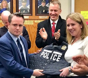 Leanne Simonsen, right, presents the first lightweight bulletproof vest to her late husband's partner, Det. Ricky Waters.
