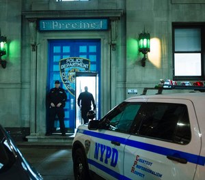 An NYPD officer stands outside the 1st Precinct in Tribeca where it is reported that approximately 30 officers have been diagnosed with COVID-19.