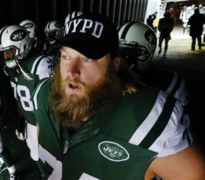 New York Jets center Nick Mangold (74) wears an NYPD hat as he waits to go on the field for the start of an NFL football game against the New England Patriots, Sunday, Dec. 21, 2014, in East Rutherford, N.J.
