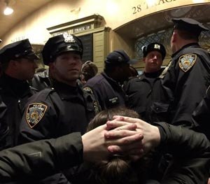 Police officers eye protesters demonstrating in Grand Central Terminal after it was announced that the New York City police officer involved in the death of Eric Garner was not indicted, Wednesday, Dec. 3, 2014, in New York. (AP Image)