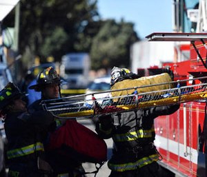 A stretcher is taken out of a fire truck at the scene of a fire that destroyed a warehouse Dec. 3, in Oakland, Calif. A deadly fire broke out during a rave at the converted warehouse in the San Francisco Bay Area.